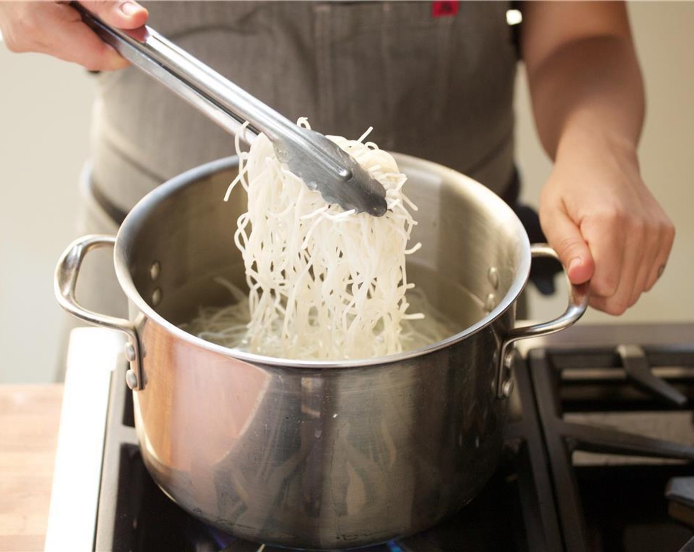 step 4 Once water is at a fast boil, add Rice Noodles (5 oz). Stir and cook for five to six minutes until cooked but still with a little bite. Using a colander, drain the noodles and lightly rinse with cold water. Drain completely and hold.