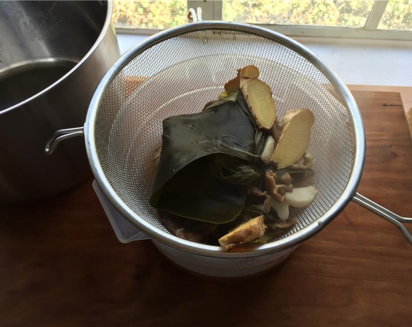 step 12 Strain the dashi into another pot. Reserve the pieces of shiitake mushrooms and place them on a parchment lined pan.