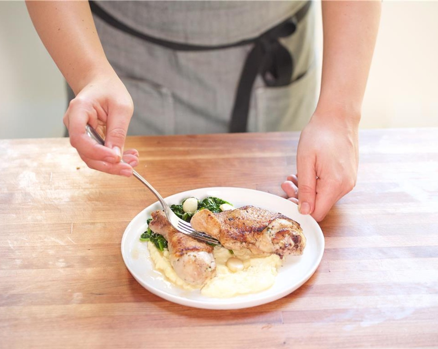 step 22 In the center of two plates, place the potato puree. Add the chicken directly on top. Set spinach on the side and spoon garlic jus from the pan over the chicken.