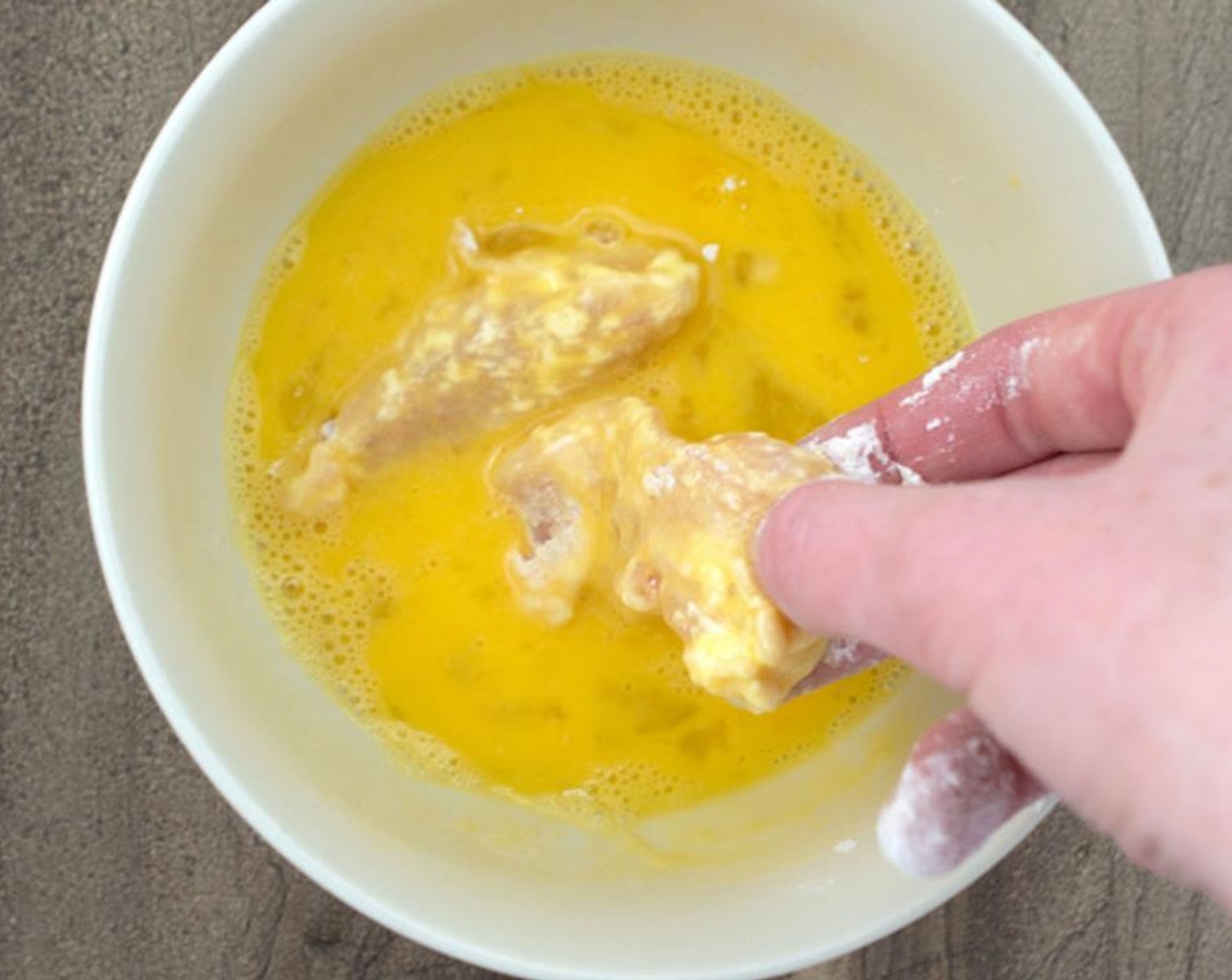 step 5 Place the floured chicken tenders in the egg mixture. Make sure to get the excess egg off before moving on to the next step.