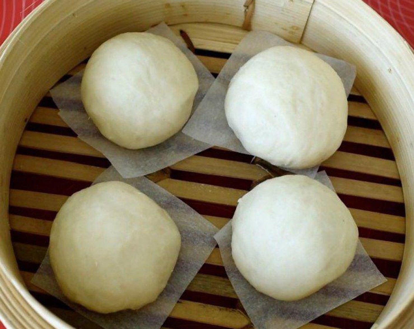 step 6 Place the dough on the parchment paper and put in a steamer. Cover the lid and let it rest for 30 minutes. The dough will grow bigger.