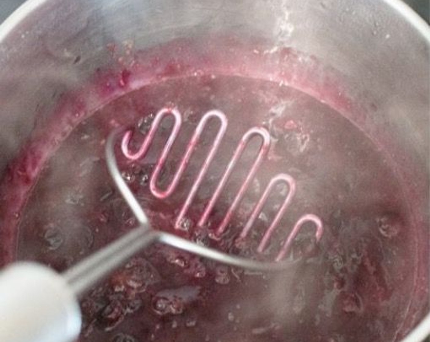 step 2 Once the blueberries have softened and are starting to break down, mash them with a fork or potato masher.