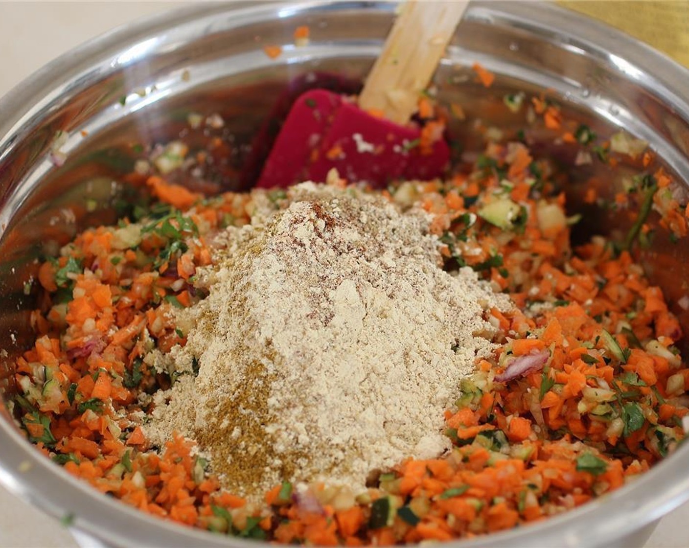 step 5 Add the zucchini to the carrots and other veggies and then top with the Chili Powder (1/2 Tbsp), Ground Cumin (1/2 Tbsp), Ground Coriander (1/2 Tbsp), and Curry Powder (1/2 Tbsp) plus an additional teaspoon. Stir with a wooden spoon or spatula to evenly mix.