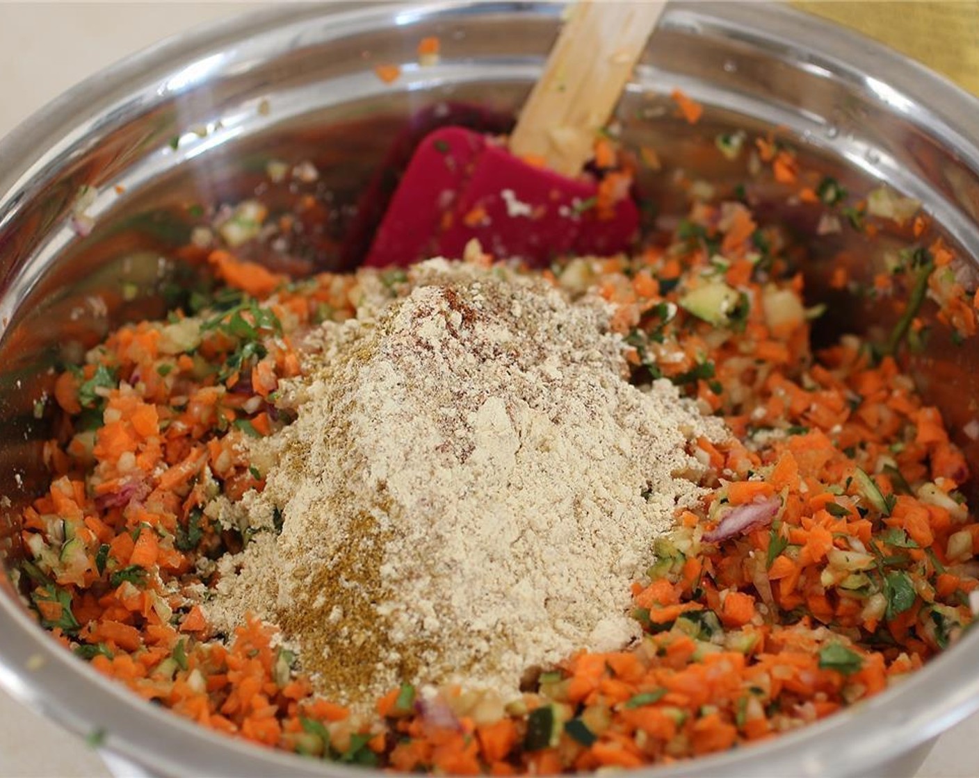 step 5 Add the zucchini to the carrots and other veggies and then top with the Chili Powder (2 tsp), Ground Cumin (2 tsp), Ground Coriander (1 tsp), and Curry Powder (1 tsp) plus an additional teaspoon. Stir with a wooden spoon or spatula to evenly mix.