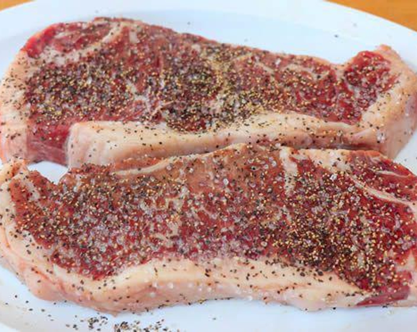 step 2 Season New York Strip Steak (2) with Kosher Salt (1 Tbsp) and Freshly Ground Black Pepper (1 Tbsp) on both sides.