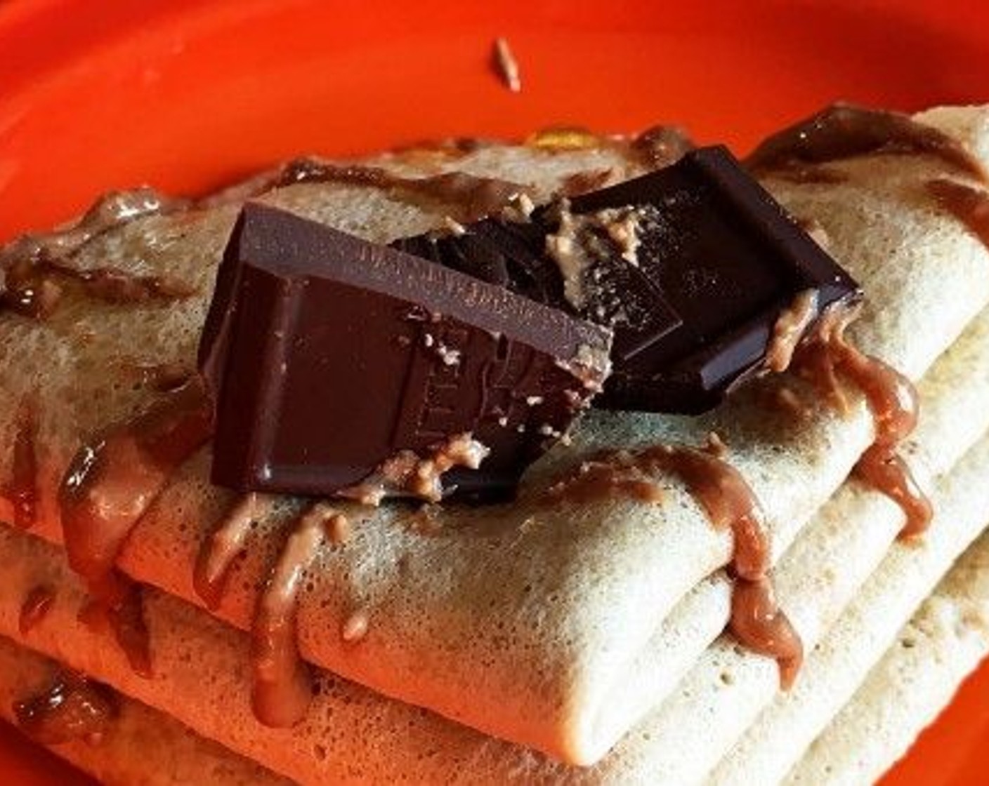 step 5 Fold each crepe, pile them up, drizzle with more Chocolate hazelnut spread, 1 tablespoon of maple syrup, dark chocolate pieces or whatever else you fancy. Serve it up!