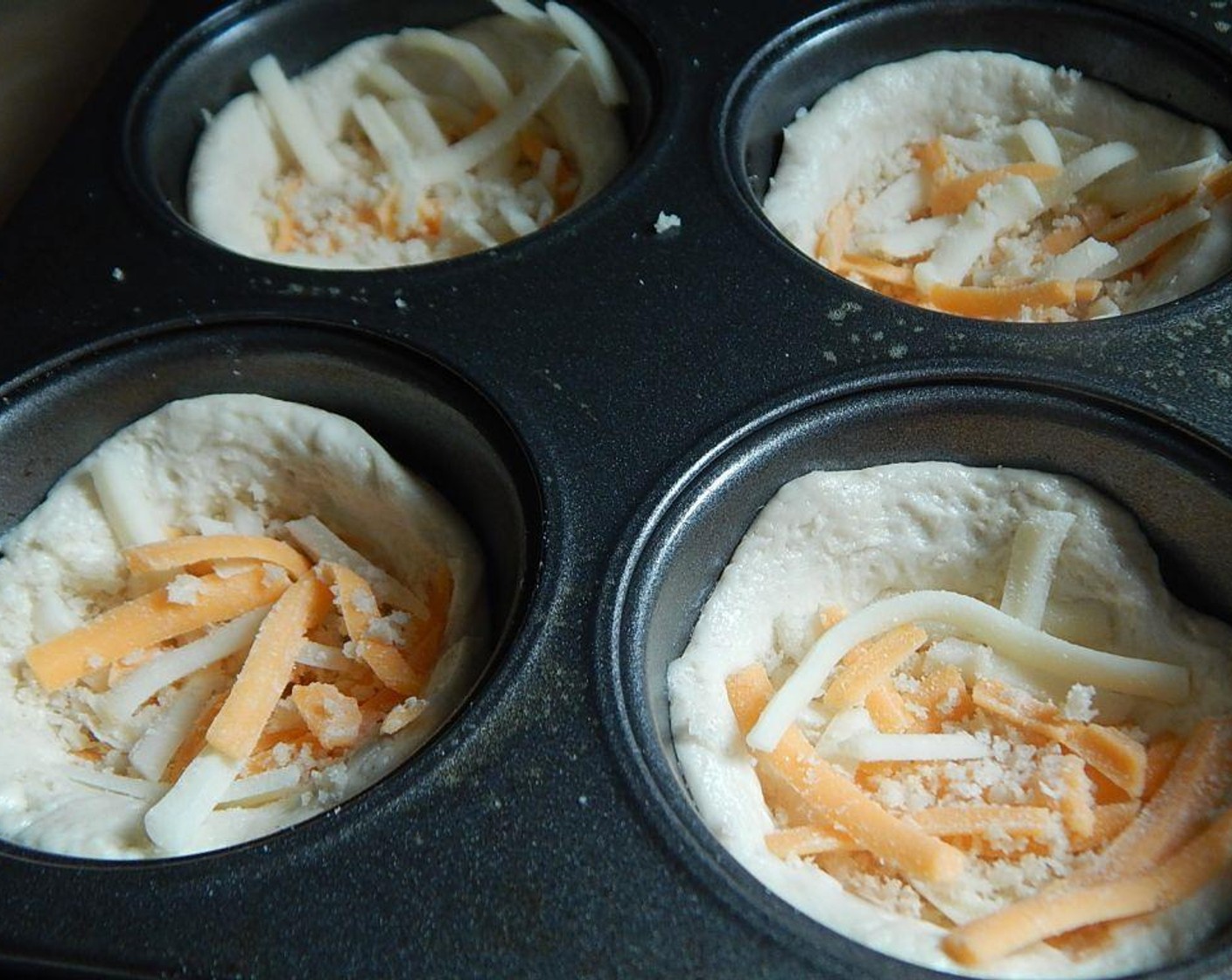 step 4 In a small bowl mix your Light Shredded Cheese Blend (1/3 cup), Parmesan Cheese (1 Tbsp) and Panko Breadcrumbs (3 Tbsp). Divide over your 10 biscuit cups, pushing it down into the bottom.