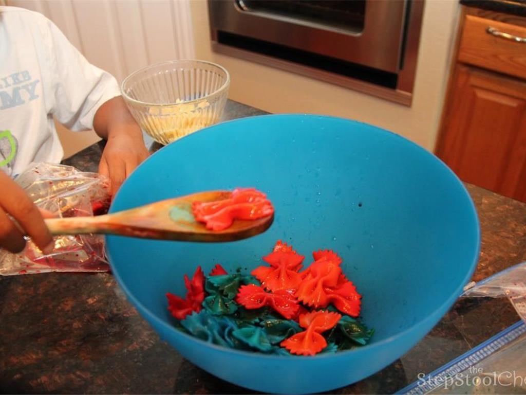 Step 6 of Rainbow Pasta Salad Recipe: Drain and rinse colored pasta to remove excess coloring.