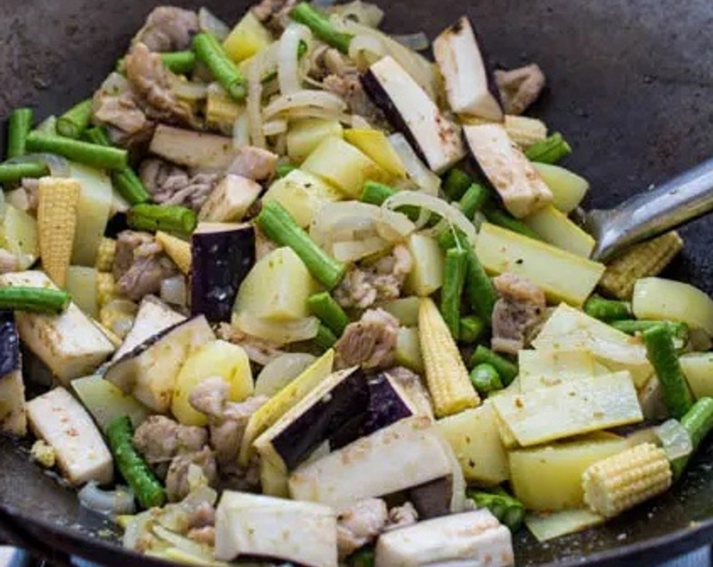 step 5 Add Eggplant (1), Green Beans (1 cup), Baby Corn (1 cup), Bamboo Shoot Strips (1/4 cup) and the potatoes to the wok. Stir well to distribute the green curry paste evenly among all of the vegetables.