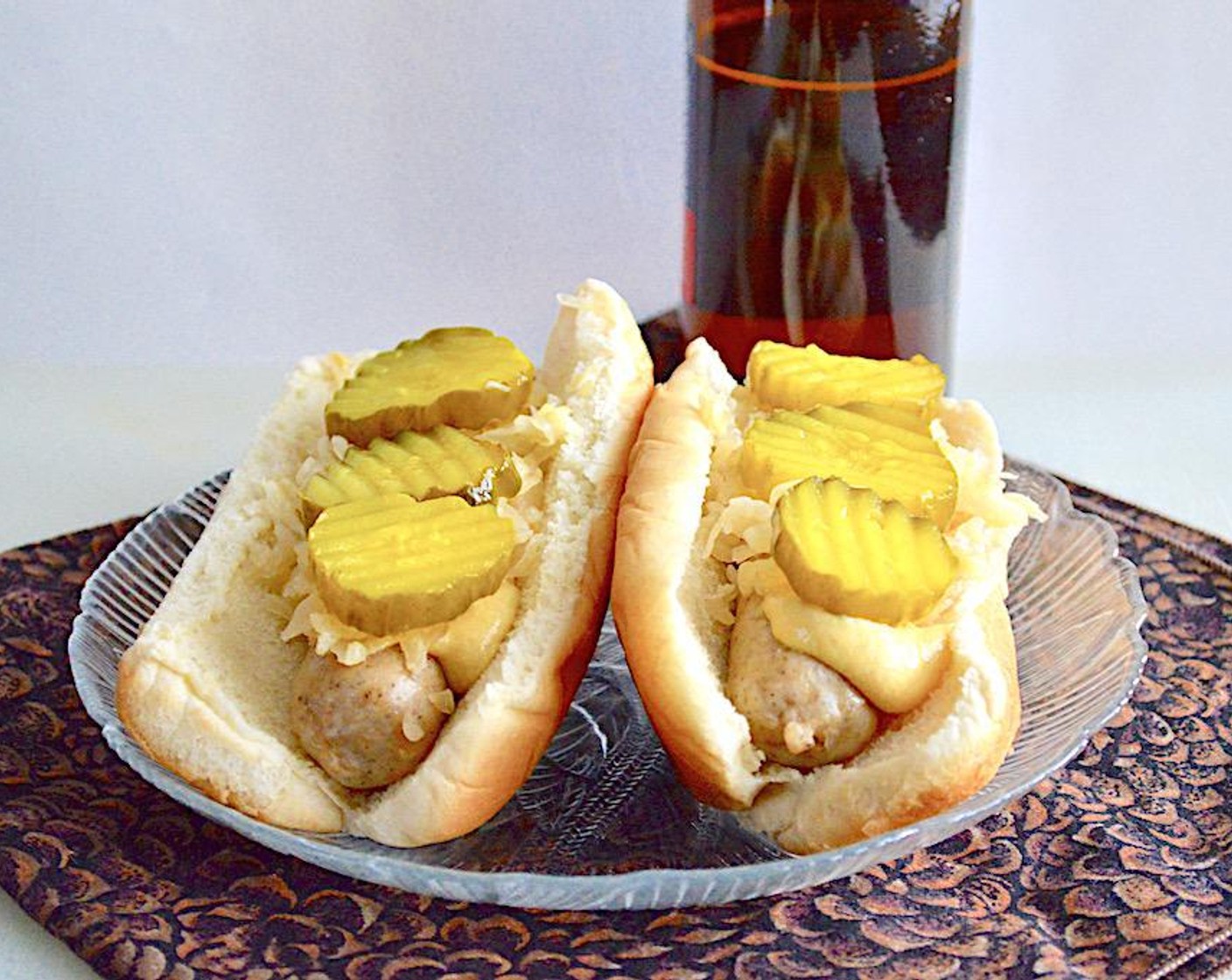 step 6 When everything is finished, it's time to assemble. Put a bratwurst link into each bun and spread a little Dijon Mustard (to taste) on each of them. Then scoop a generous scoop of the sauerkraut mixture on each of them, followed by some Dill Pickles (to taste) chips on the very top. Serve them immediately with your favorite sides! Enjoy!