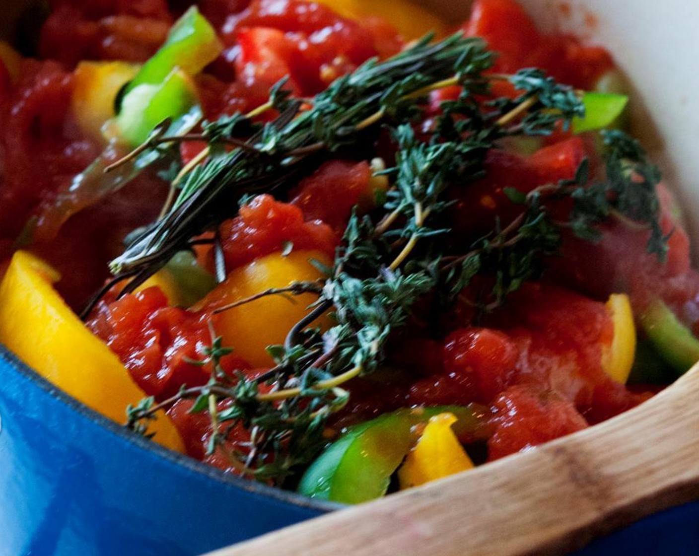 step 9 Add Garlic (6 cloves), Whole Peeled Tomatoes (2 cans), bell peppers, Fresh Rosemary (to taste), and Fresh Thyme (to taste). Season with Salt (to taste) and Ground Black Pepper (to taste).