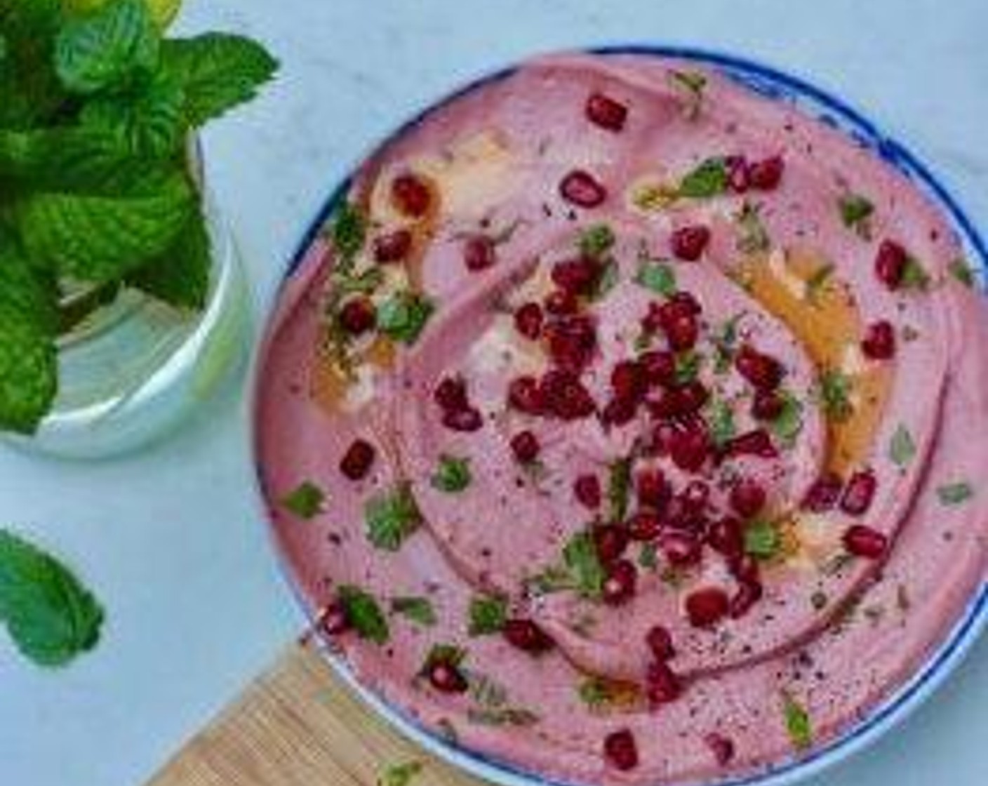 step 2 Garnish with Oil (to taste), Fresh Mint Leaves (1 pinch), Ground Black Pepper (1 dash), and Pomegranate Seeds (1 handful).