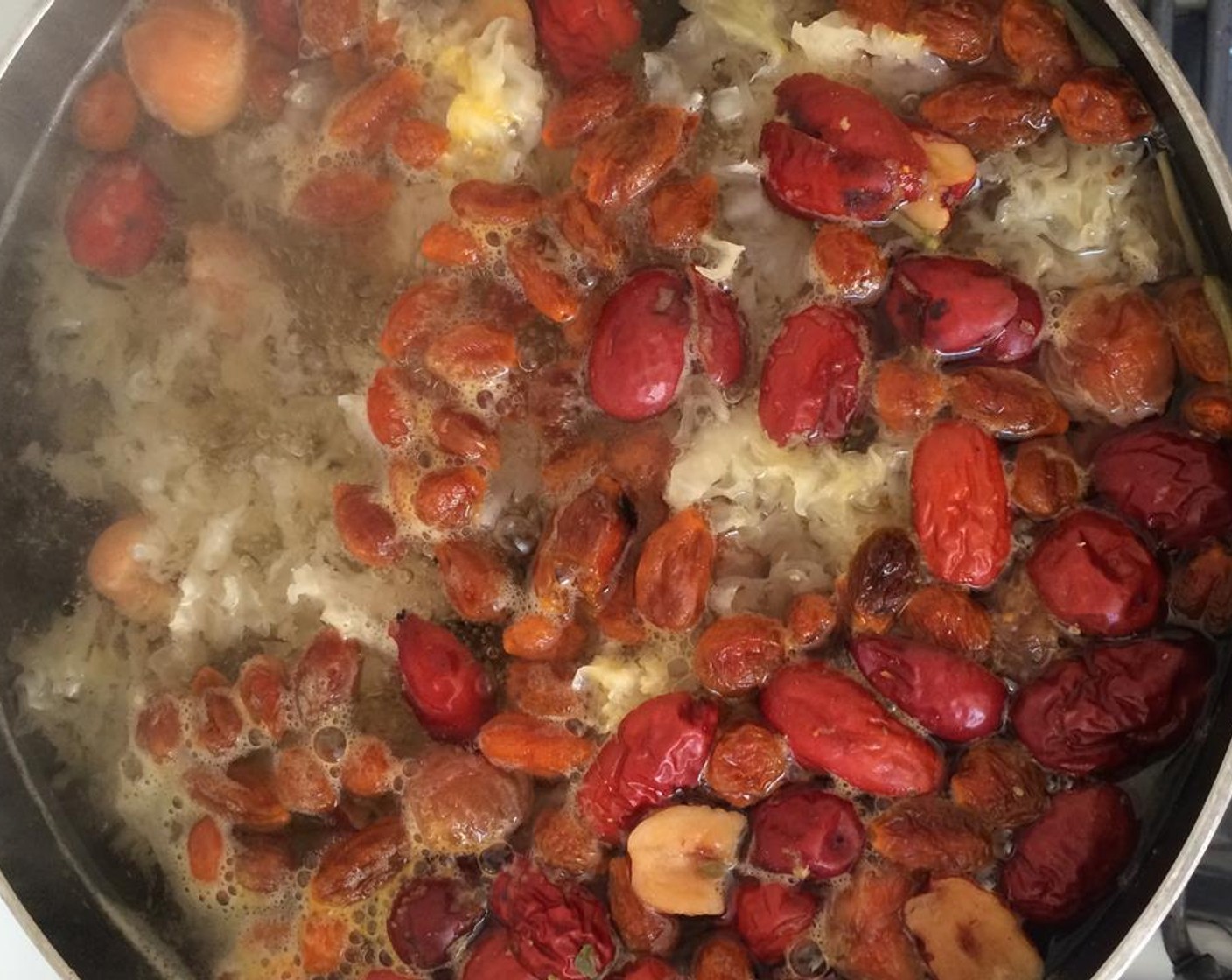 step 5 In a large pot, add Water (8 cups), the chopped mushrooms, dried longan, red dates, and goji berries.