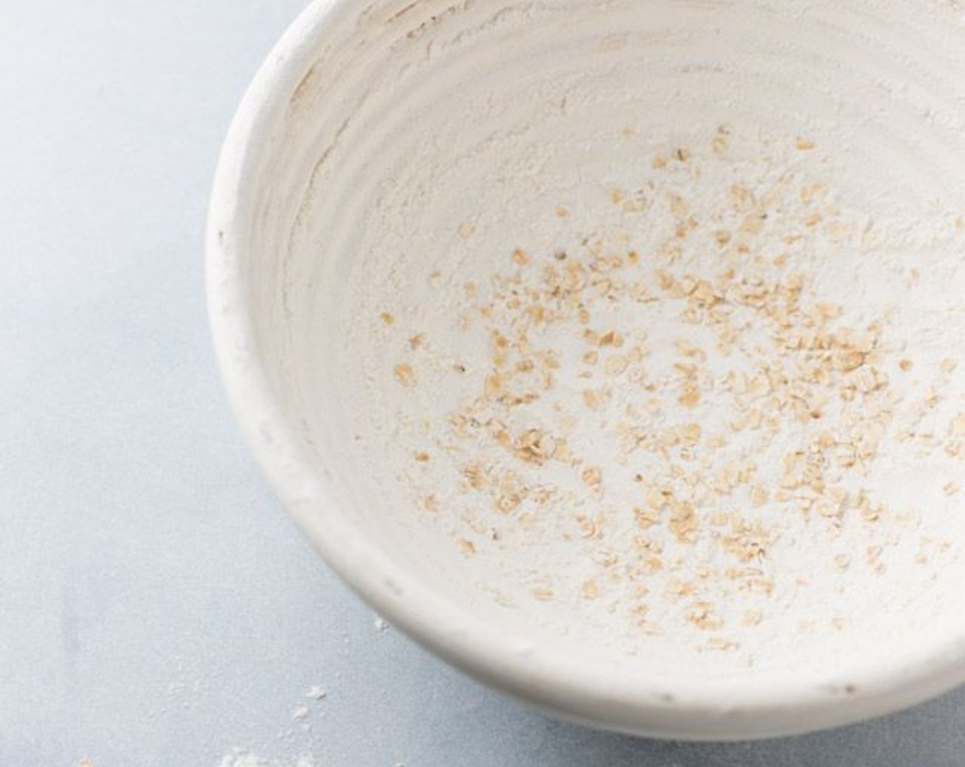 step 5 While dough is resting, prepare the banneton by generously flouring the inside of the basket. Make sure to get it into the creases and use your fingers to press it onto the sides. Be patient and gentle so the flour stays on the sides. Sprinkle the Oatmeal (1/2 Tbsp) into the basket.