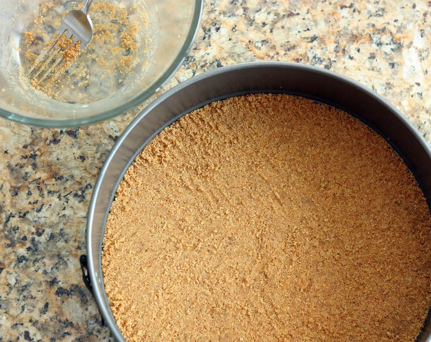 step 4 Press the crumb mixture evenly into the bottom of a 10-inch spring form pan with a fork, pushing the mixture onto the bottom and not letting it spread up the sides.