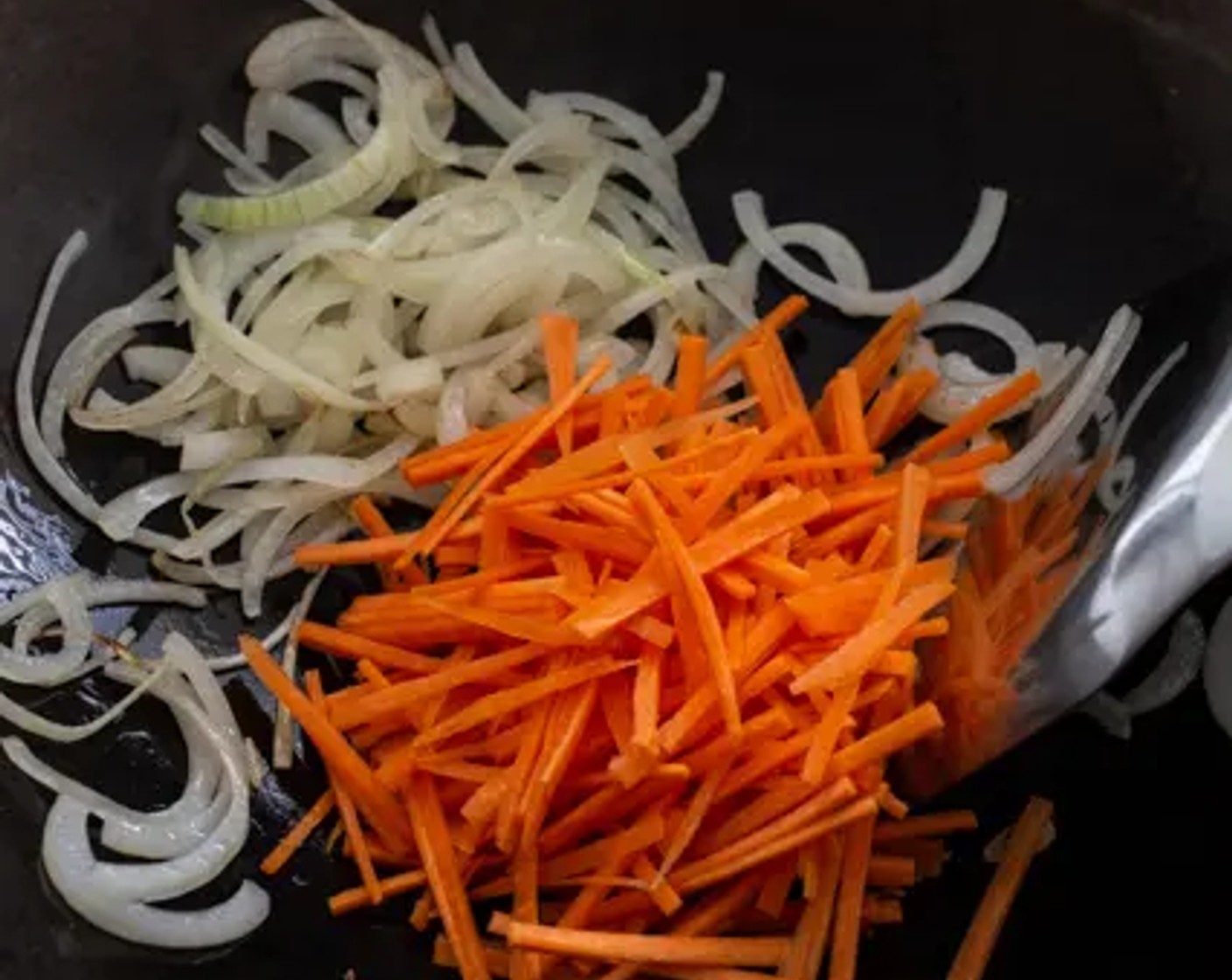 step 4 Heat Oil (3 Tbsp) in a wok over medium-high heat. Add Carrot (1) and Onion (1) to the wok.