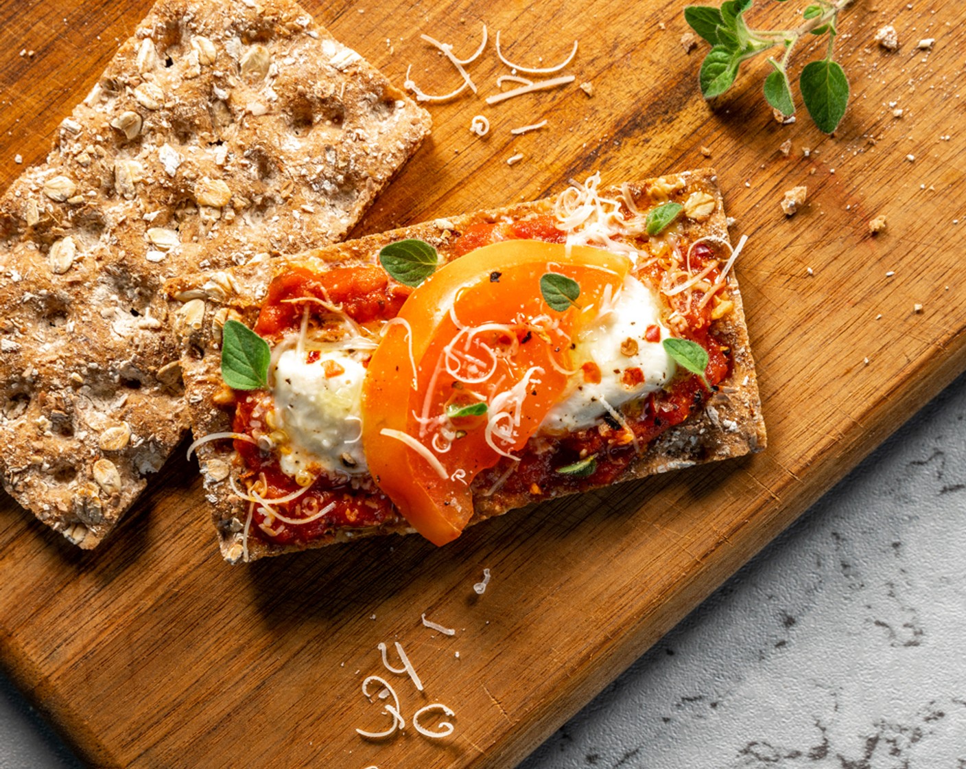 step 4 Once out of the oven, finish your crispbreads with a spritz of 1 Tbsp of Lemon Juice (1), a drizzle of Truffle Oil (1 tsp), and sprinkle with Grated Parmesan Cheese (2 Tbsp), Crushed Red Pepper Flakes (1 Tbsp), and Dried Oregano (1 Tbsp).