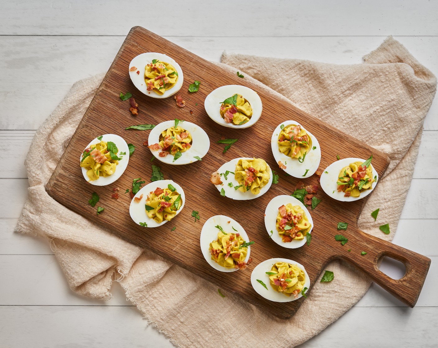 step 4 Using a piping bag or a spoon, fill the egg whites with the avocado and yolk mixture. Top with more bacon pieces, and garnish with a sprinkle of Fresh Cilantro (to taste) and Cayenne Pepper (to taste).