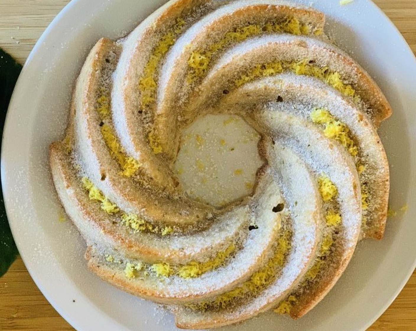 step 7 Once cooked, let the cake cool completely on a wire rack. Then dust with powdered sugar and some lemon zest.