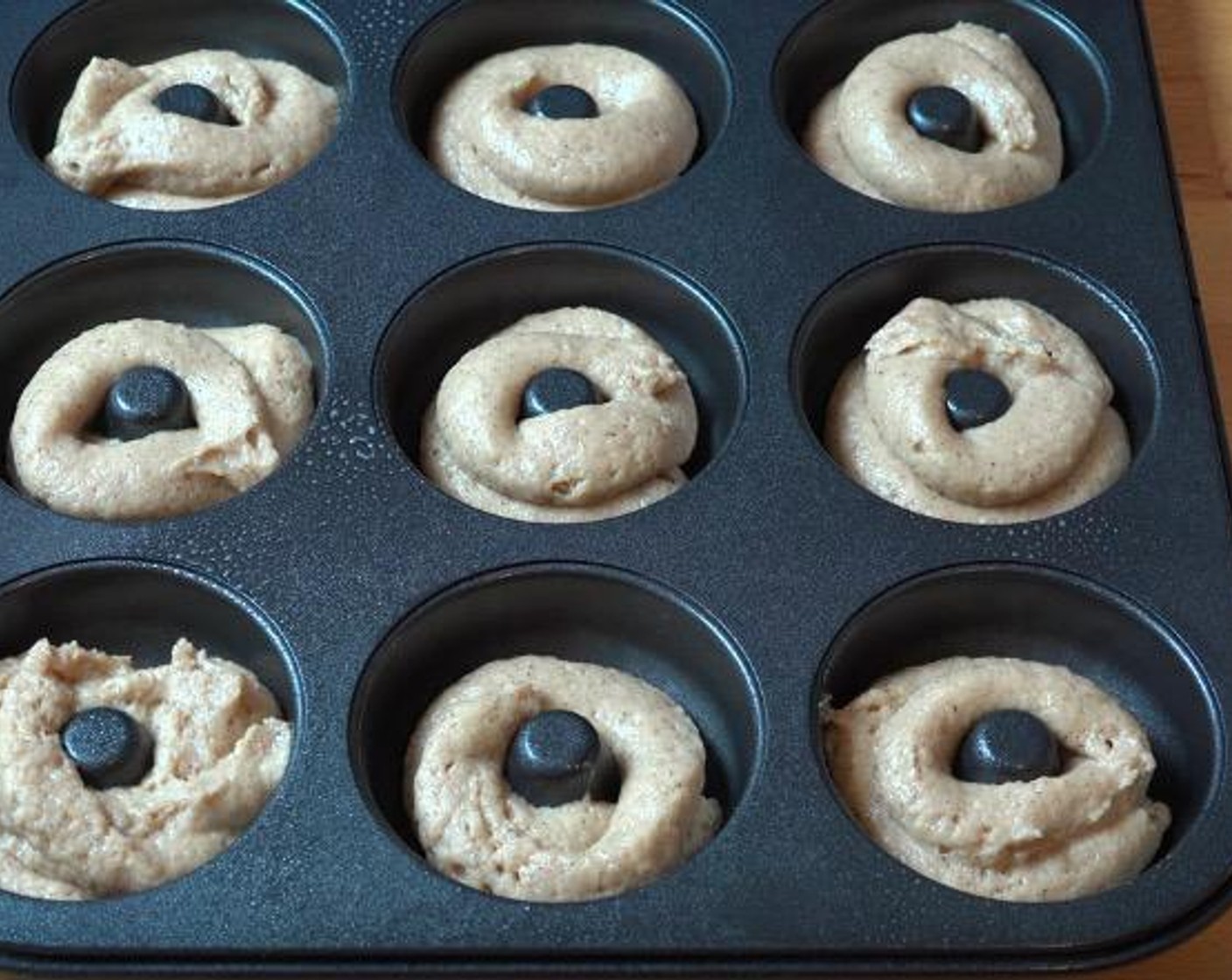 step 4 Transfer the batter to a plastic bag. Cut a small hole in the bottom corner of the bag and squeeze the batter into a lightly greased donut pan, filling each hole about 3/4 of the way.