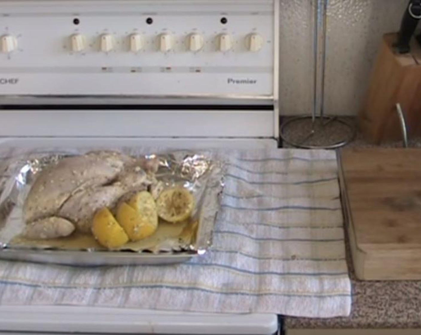 step 3 Take out the chicken and the lemons from the bag, and put it on a baking tray. Bake for 45 minutes to 1 hour at 190 degrees C (375 degrees F).