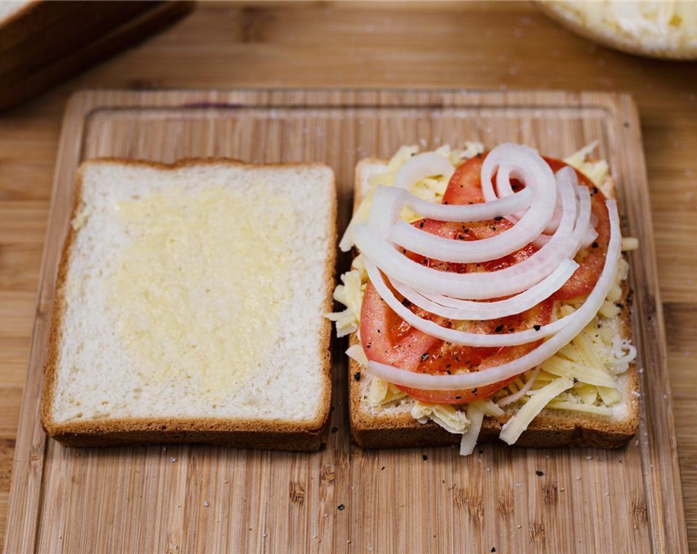 step 7 Add slices of onion. Butter the other slice of bread with butter.