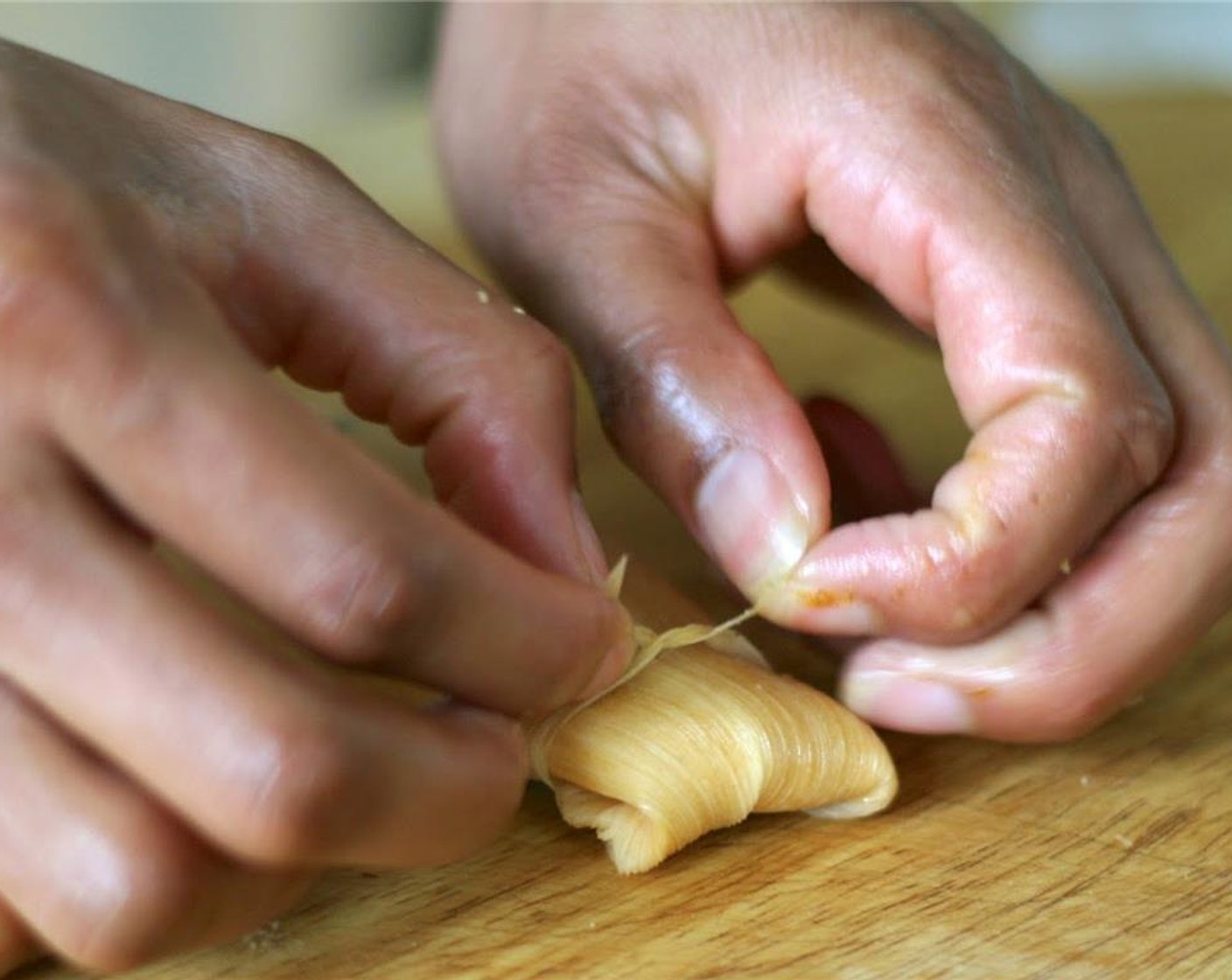 step 10 Wrap husk around, fold up the smaller bottom end and secure with string or piece of husk.