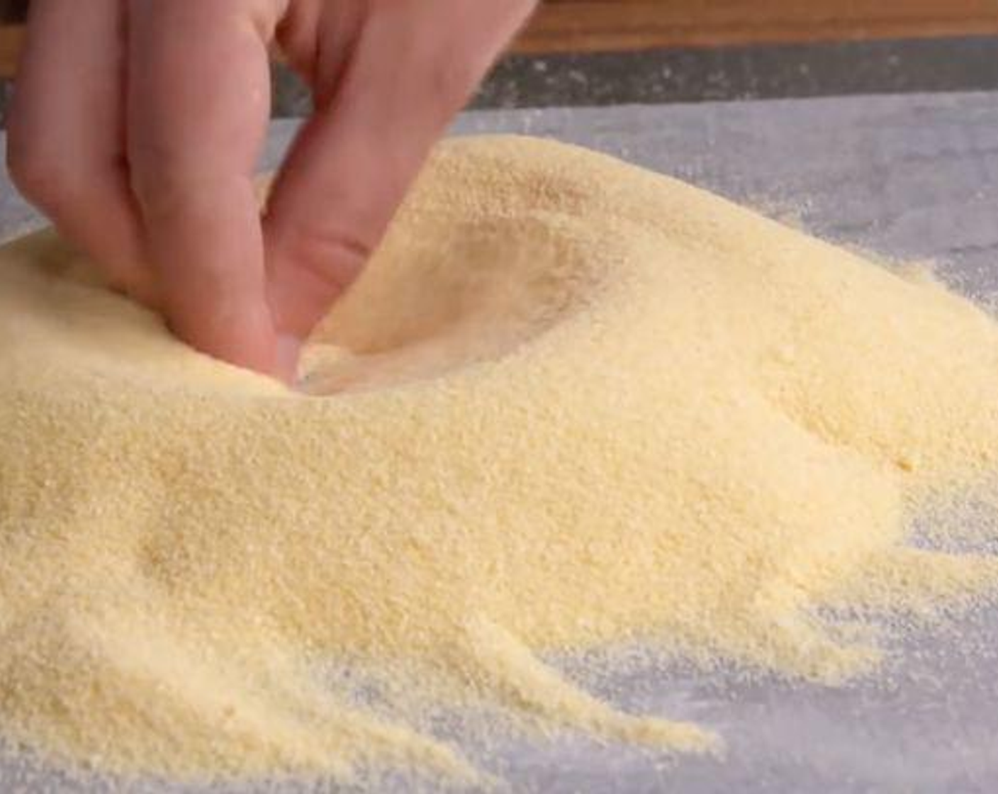 step 1 Place the Semolina Flour (3 cups) on a flat surface and make a well in the center of the flour.