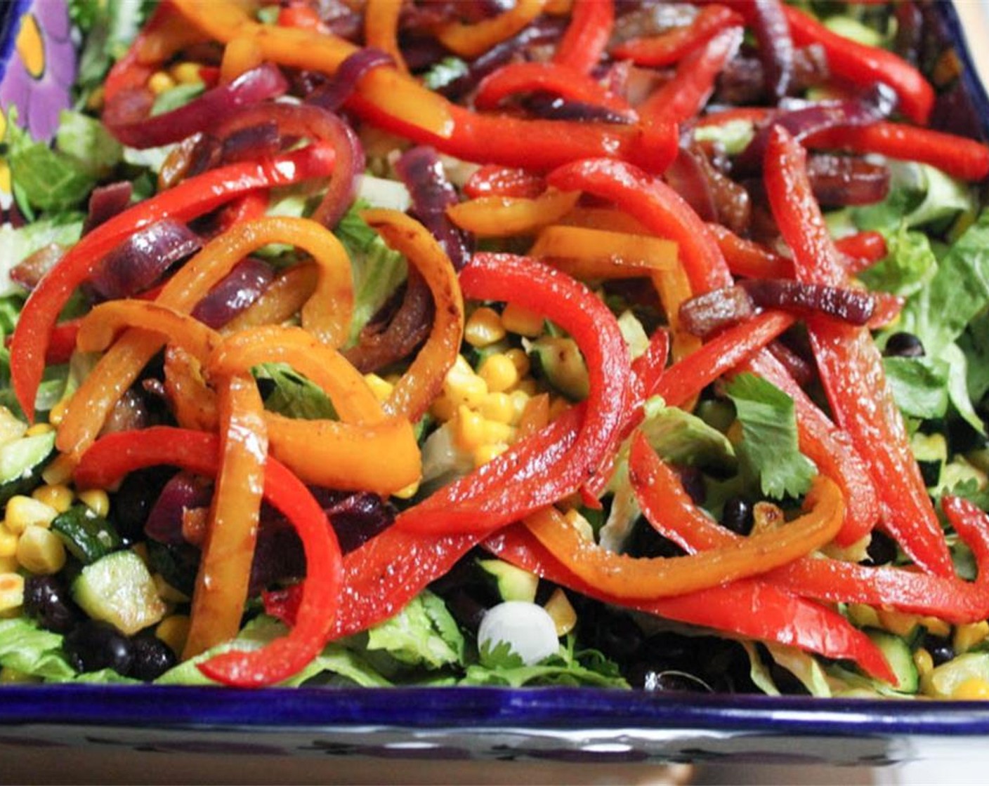 step 7 Add the corn, zucchini, and GOYA® Black Beans (3/4 cup) to the greens. Drizzle with the chipotle vinaigrette and gently toss to coat. Add the bell pepper mixture in an even layer over the dressed salad.