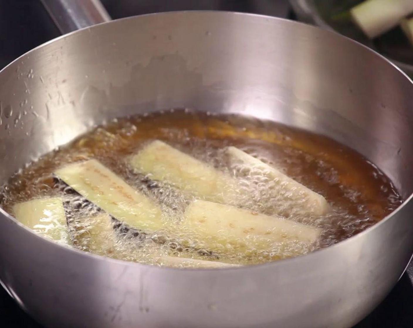 step 1 Slice Eggplant (1) into strips, fry in a hot pan with cooking oil.