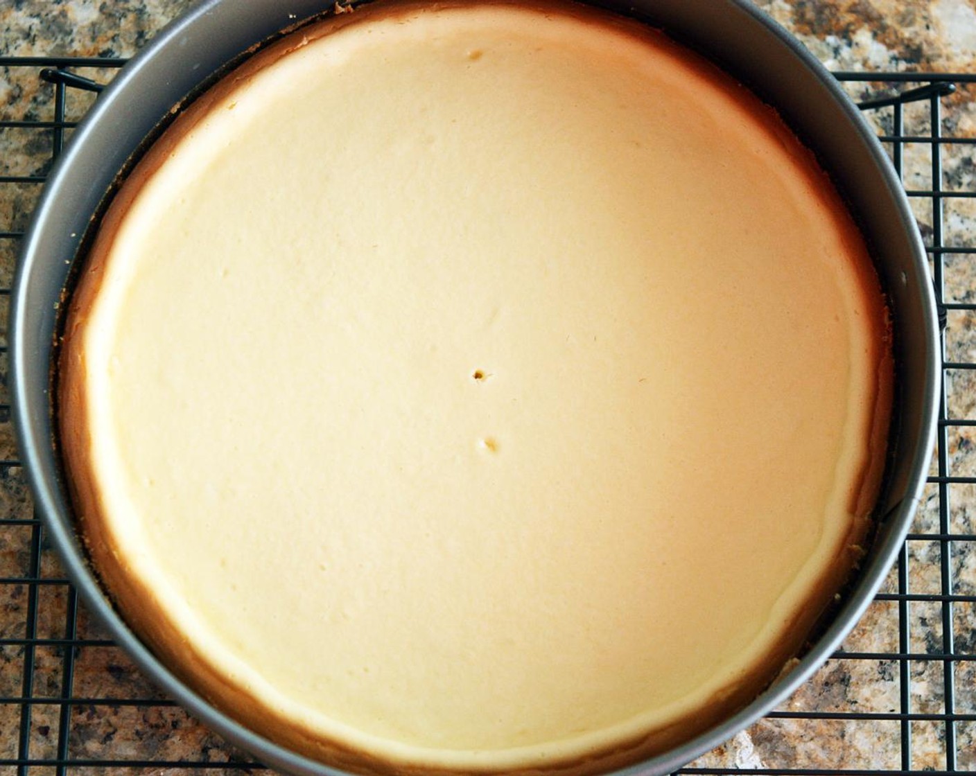 step 10 Bake for 45-50 minutes until the center of the cheesecake is not jiggling. Remove to a cooling rack and run a knife around the edges of the pan. The cheesecake will deflate as it cools. Cool to room temperature, then refrigerate.