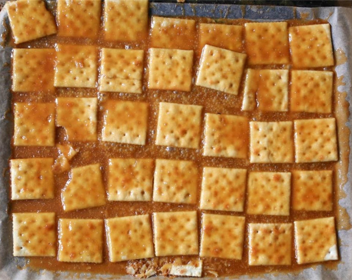 step 5 Transfer the Saltines to the oven and bake for 4 minutes. The toffee should be bubbling and slightly darker in color. The crackers will spread, and that's okay.