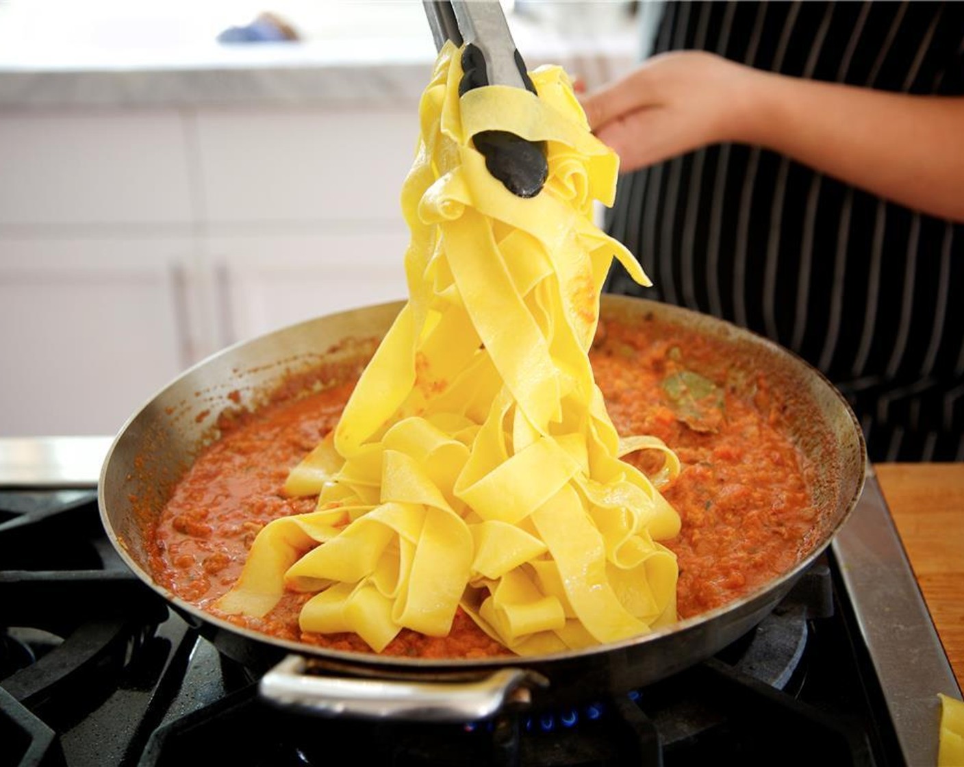 step 15 Drain pappardelle pasta into a colander. Add the pappardelle and chopped parsley to the simmering sauce and toss until all pasta is well coated. Remove from heat and keep warm until plating.