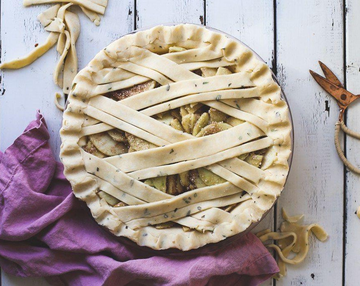 step 6 Dump the apples into the pie crust, and evenly distribute. On a well-floured surface, roll out the remaining smaller disk of dough, and cut into one-inch thick strips, and place on the pie in a diagonal lattice. Crimp edges. Cut excess dough hanging off the pie pan, and fold inward.