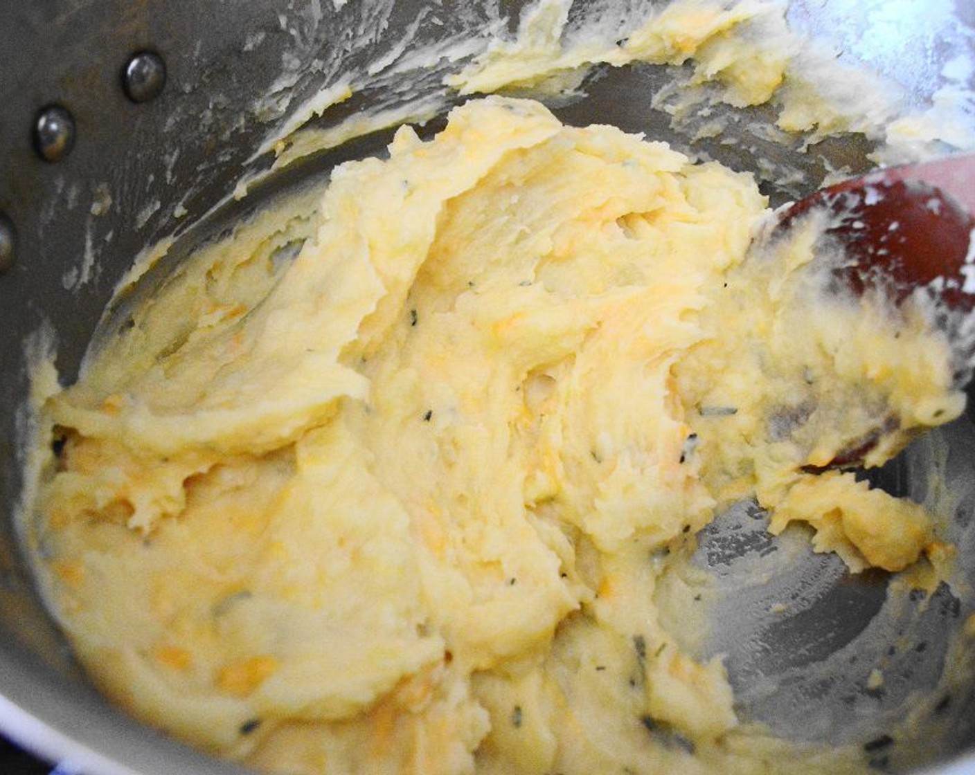 step 8 Drain the potatoes and return them to the pot they cooked in. Pour the hot butter mixture all over them and add the Extra Sharp Cheddar Cheese (1 cup) and Salt (1 pinch). Mash the mixture all together and let it cool for a minute.