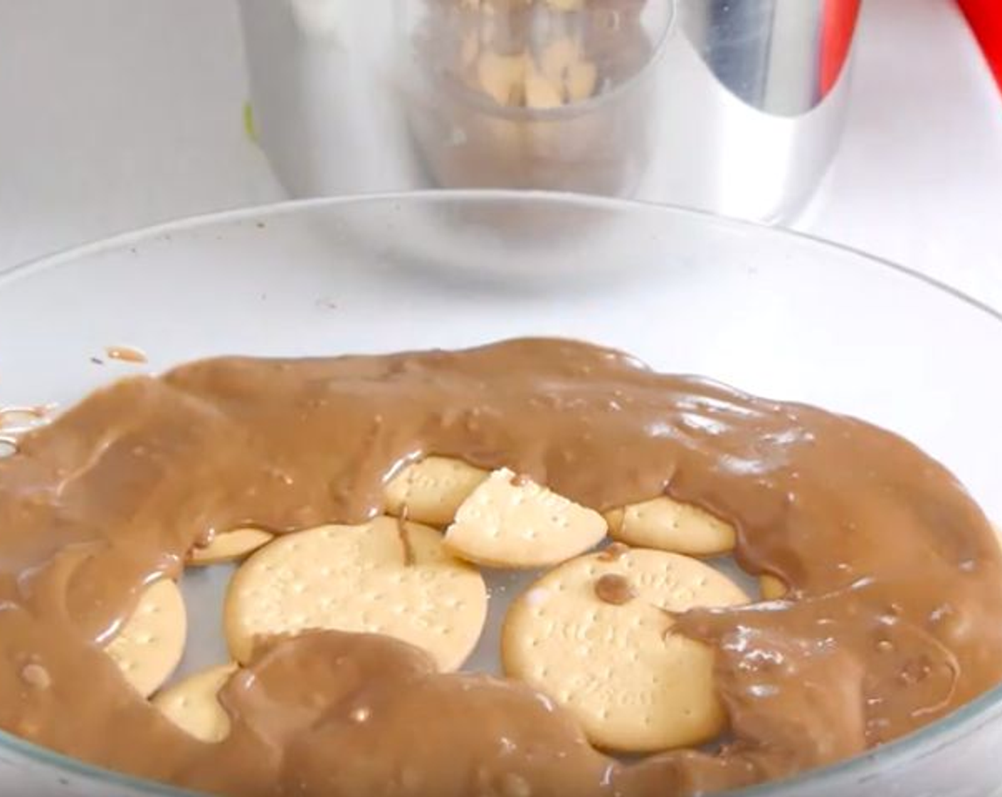 step 4 In a tray, start to build the layers of Digestive Biscuits (3 cups) and chocolate by dunking the biscuits in milk and placing them on the tray. Build the layers until finishing all the ingredients leaving some chocolate for the top.