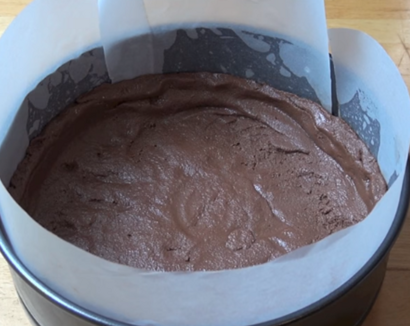 step 2 Line a 20-centimeter springform tin with baking paper. Gently press the Tim Tam mixture into the base and make a bit of a border along the sides.