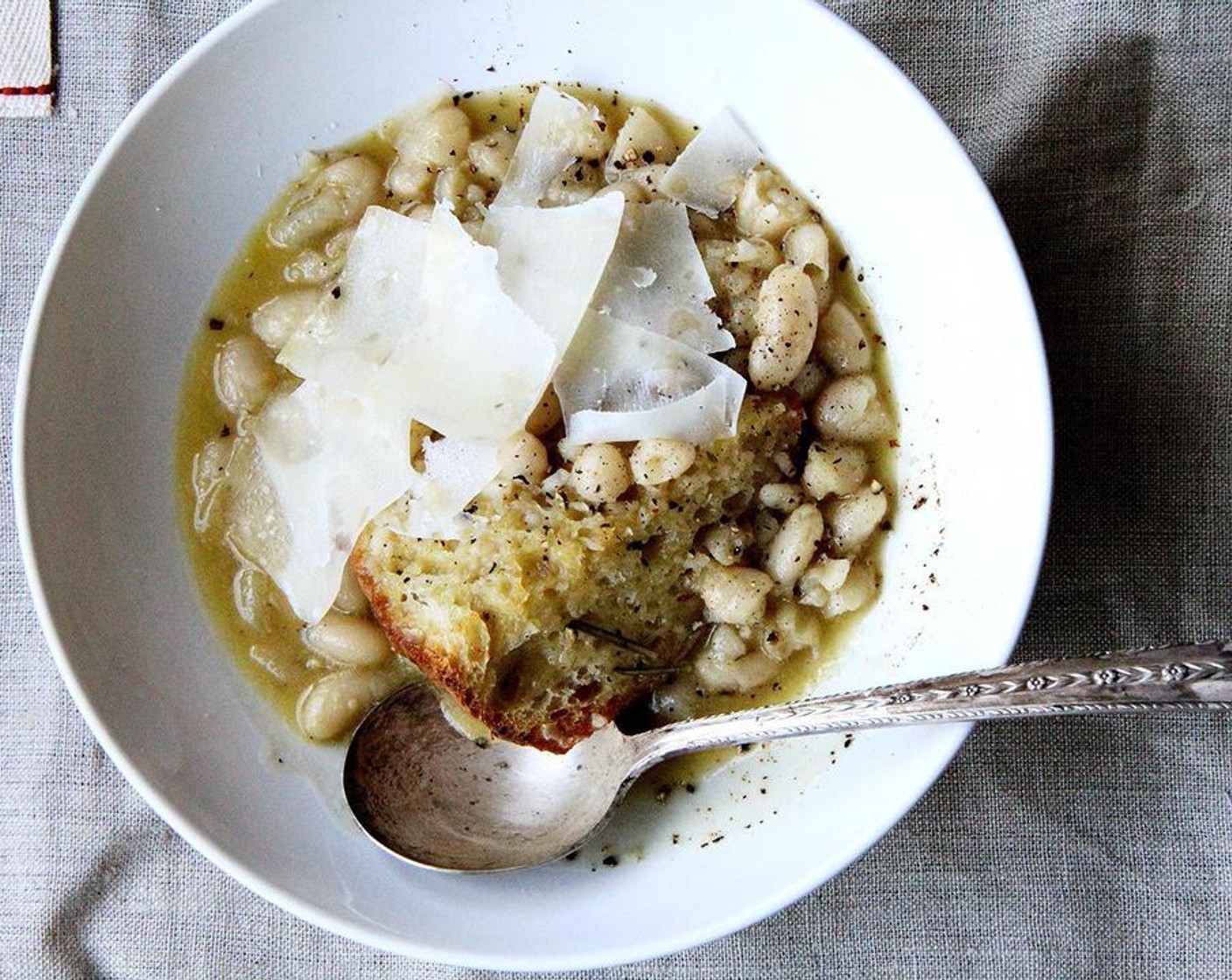 step 4 Place Bread (to taste) into soup bowls. Ladle beans over top. Shave Parmigiano-Reggiano (to taste) over top.