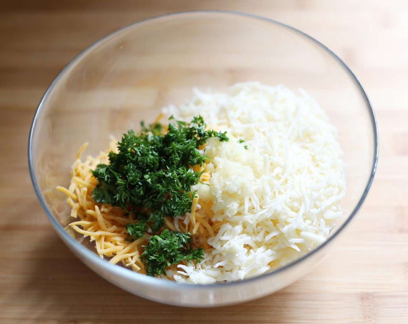 step 5 In a bowl, combine the Mozzarella Cheese (1 cup), Cheddar Cheese (1 cup), Fresh Parsley (1 Tbsp), and Garlic (1 clove).