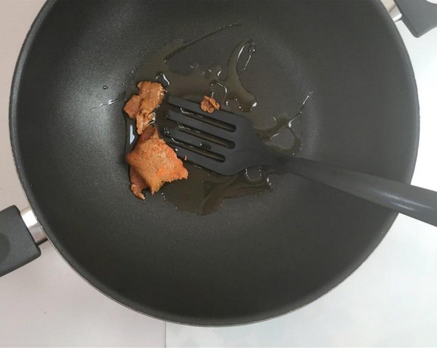 step 2 Pour Vegetable Oil (1 splash) in a large wok or non-stick pan and place it over medium-high heat. Once the oil is hot, add the Green Curry Paste (2 Tbsp).