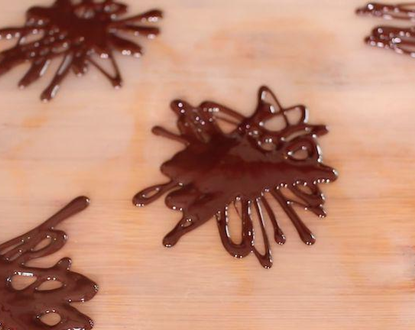 step 1 Heat the 70% Dark Chocolate (3/4 cup) in a bowl over a saucepan of hot water or melt in the microwave. When melted, using a spoon make swiggly decorations onto parchment paper or a silicone mat and then put into the fridge to harden until ready to serve.