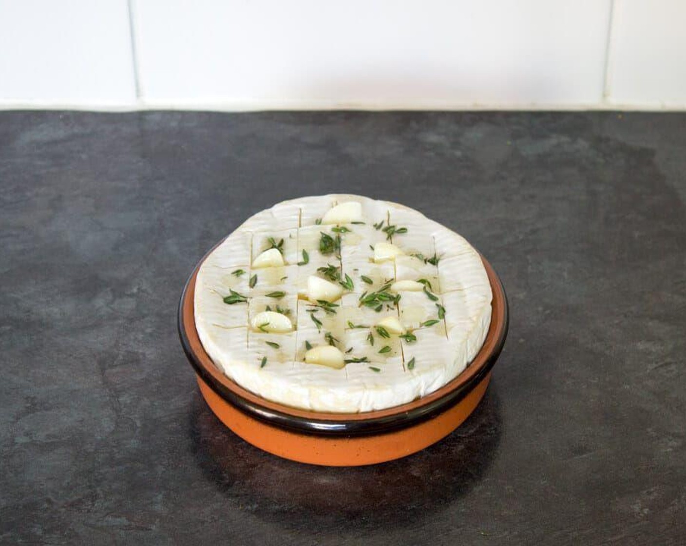 step 3 Tear the leaves off Fresh Thyme (1 sprig) and scatter them over the top. Press a few into the cuts to really get the flavor in. Drizzle a little Garlic Infused Olive Oil (as needed) over the top then place it onto a baking tray. Bake in the center of the preheated oven for 20 minutes, then let it stand for 5 minutes to cool and set slightly before serving.