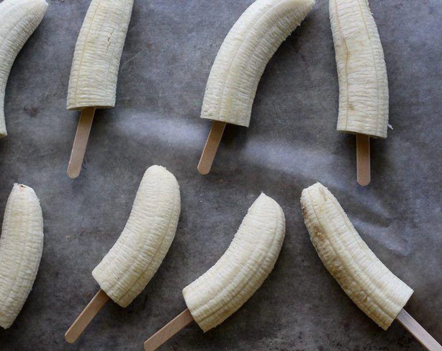 step 1 Peel Bananas (4) and cut in half. Gently insert a popsicle stick the center of each banana half.