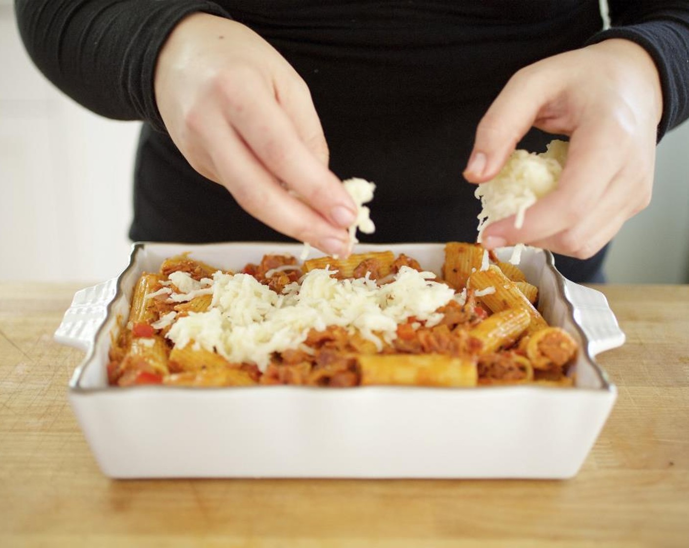 step 13 Pour the tomato cream sauce over the rigatoni.  Stir in the Parmesan Cheese (1/4 cup). Transfer the pasta to a baking dish, sprinkle the Shredded Mozzarella Cheese (1 1/3 cups), evenly over the top and bake for 20 minutes until the cheese starts to turn a golden brown.