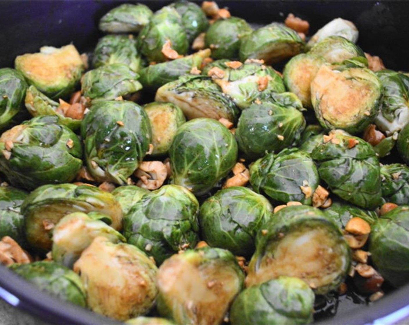 step 2 Spread the Brussels Sprouts (16) evenly on a large baking dish. Mix Toasted Sesame Oil (1/4 cup), Soy Sauce (2 Tbsp), Sriracha (1 dash) and Worcestershire Sauce (1 dash) in a bowl. Pour over brussels sprouts. Toss in Cashew Nuts (1/2 cup) and mix well.