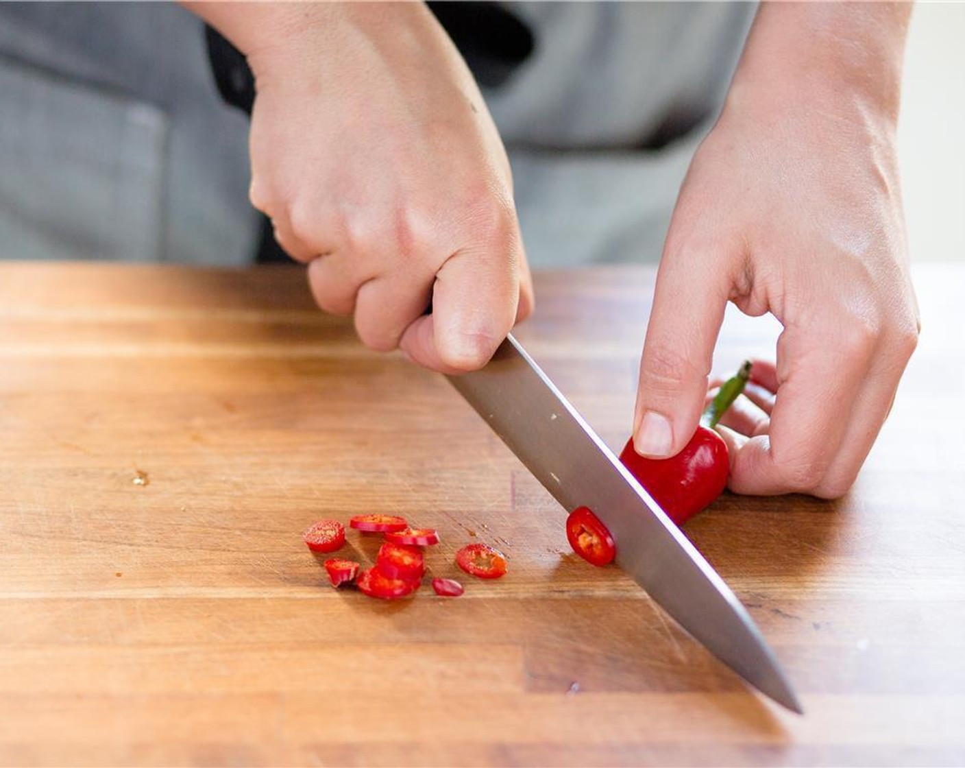 step 3 Finely chop Garlic (1 clove) add to large bowl with marinade. Cut half of the Red Fresno Chili Peppers (1 1/2 Tbsp) in half, widthwise. Cut into quarter inch sliced rings and place into a second large bowl.