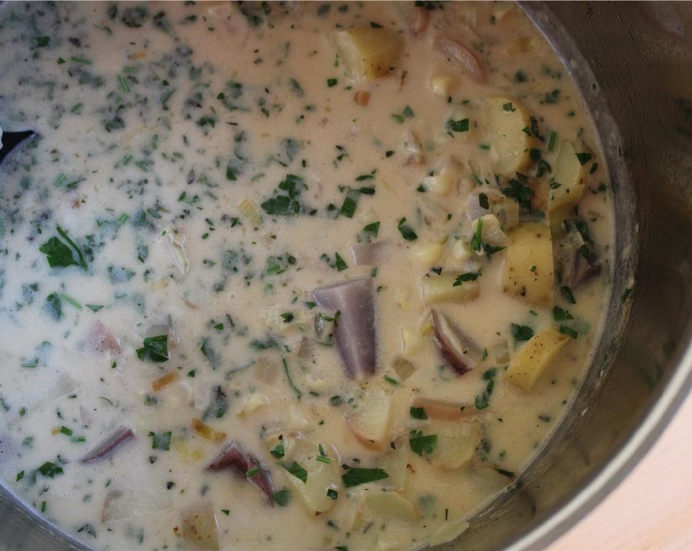 step 7 Then add mixed diced heirloom potatoes, corn, and Chicken Stock (3 cups), turn heat up and cover, boiling for about 10 minutes or until the potatoes are soft enough to crush.