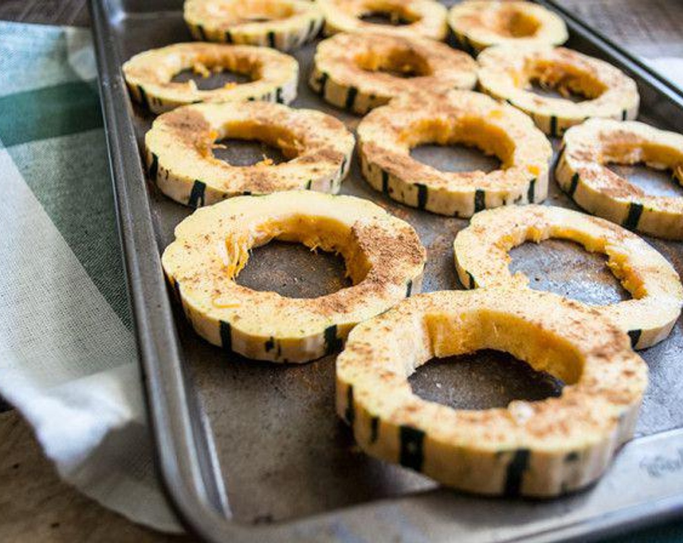 step 2 Spray baking sheet with Coconut Oil Cooking Spray (as needed) then slice Delicata Squash (1) in approx 1/2 inch slices, remove all seeds and sprinkle with Ground Cinnamon (1/2 tsp) and Pumpkin Pie Spice (1/4 tsp).
