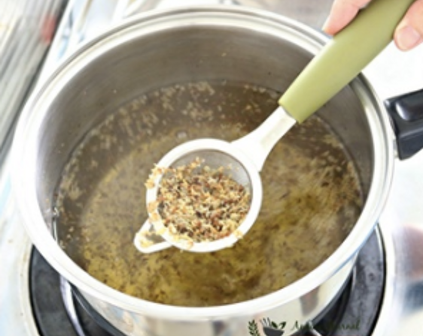 step 2 Stir to boil under medium heat. Lower heat and continue to stir mixture for another minute. Remove osmanthus flowers with a sieve but reserve some for decoration.
