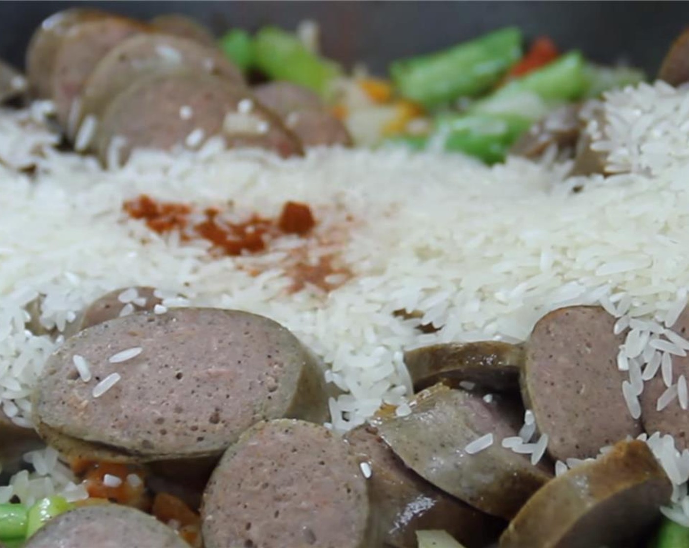 step 4 Put the sausages back in and add the Smoked Paprika (1 tsp) and White Rice (1 cup). Stir for a minute or so.